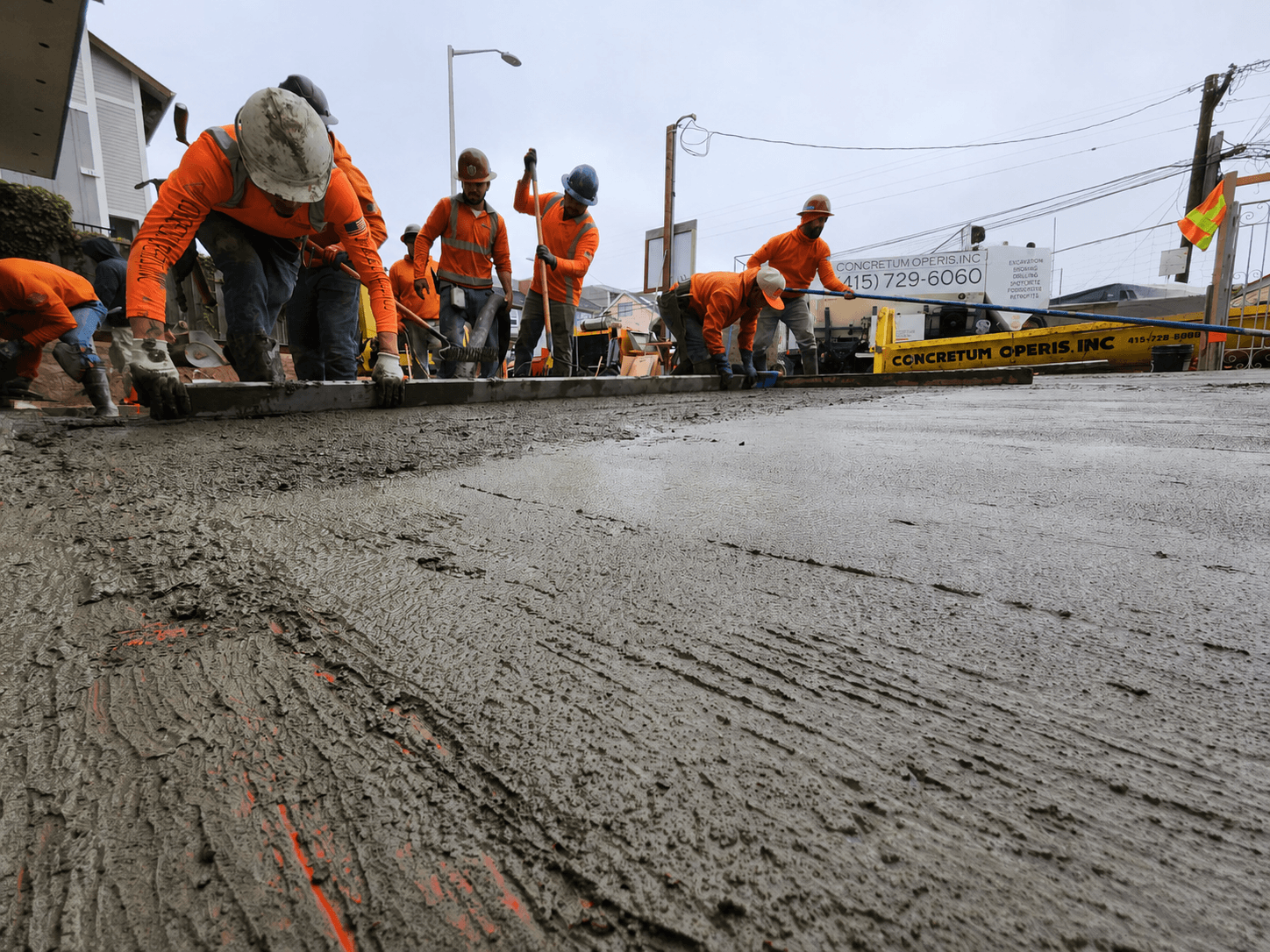 Crew finishing a fresh concrete pour next to a Concretum Operis truck in Richmond, CA — Vertido de concreto Richmond California