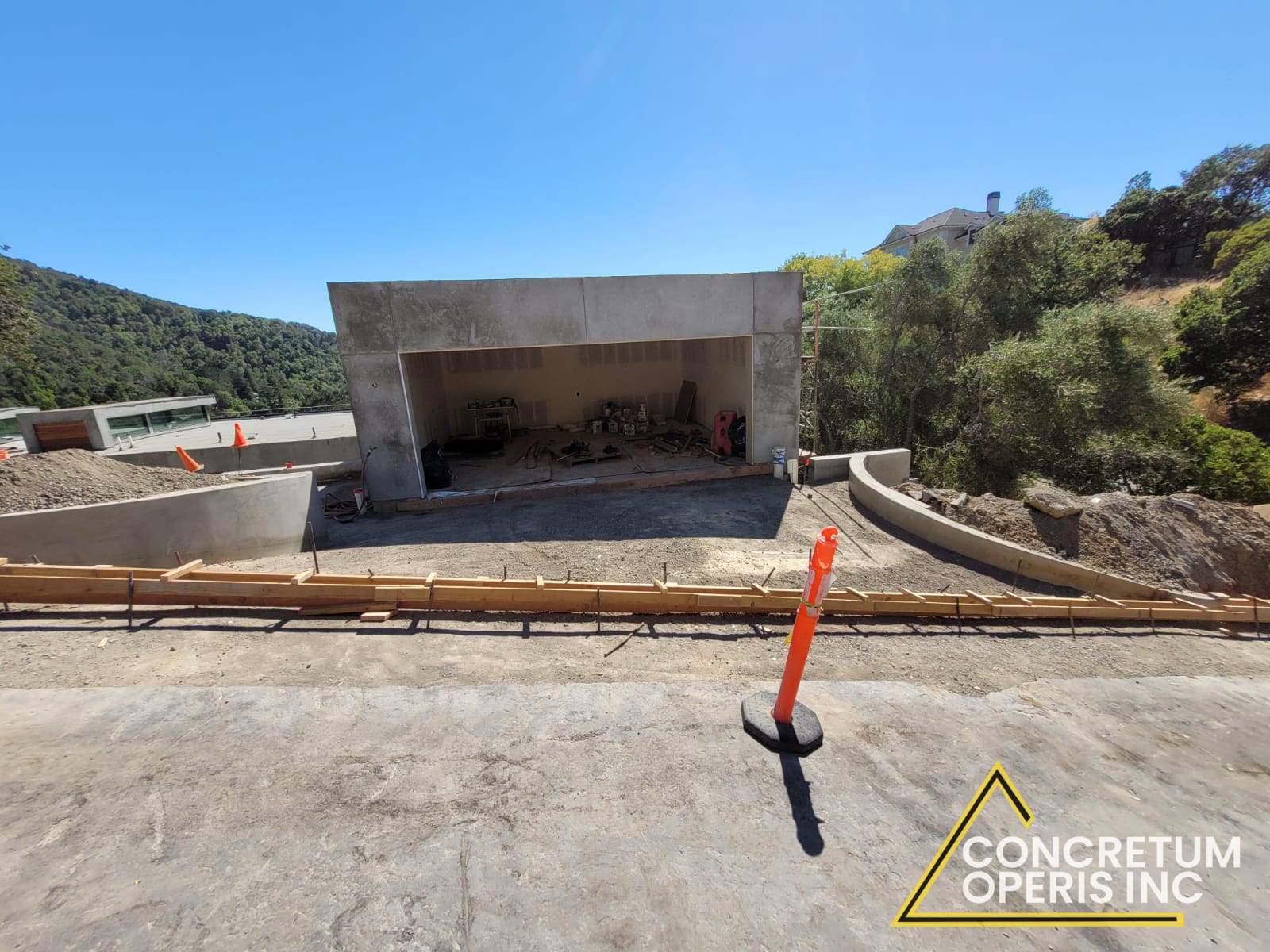Finished concrete garage shell overlooking a hillside with a curved retaining wall in San Rafael, CA