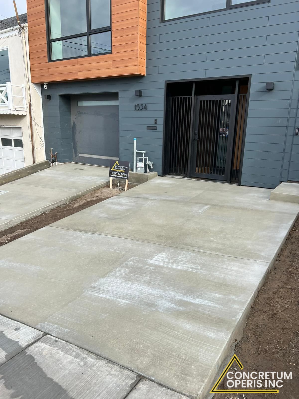 Finished concrete driveway and entryway outside a modern gray townhouse in San Francisco, CA