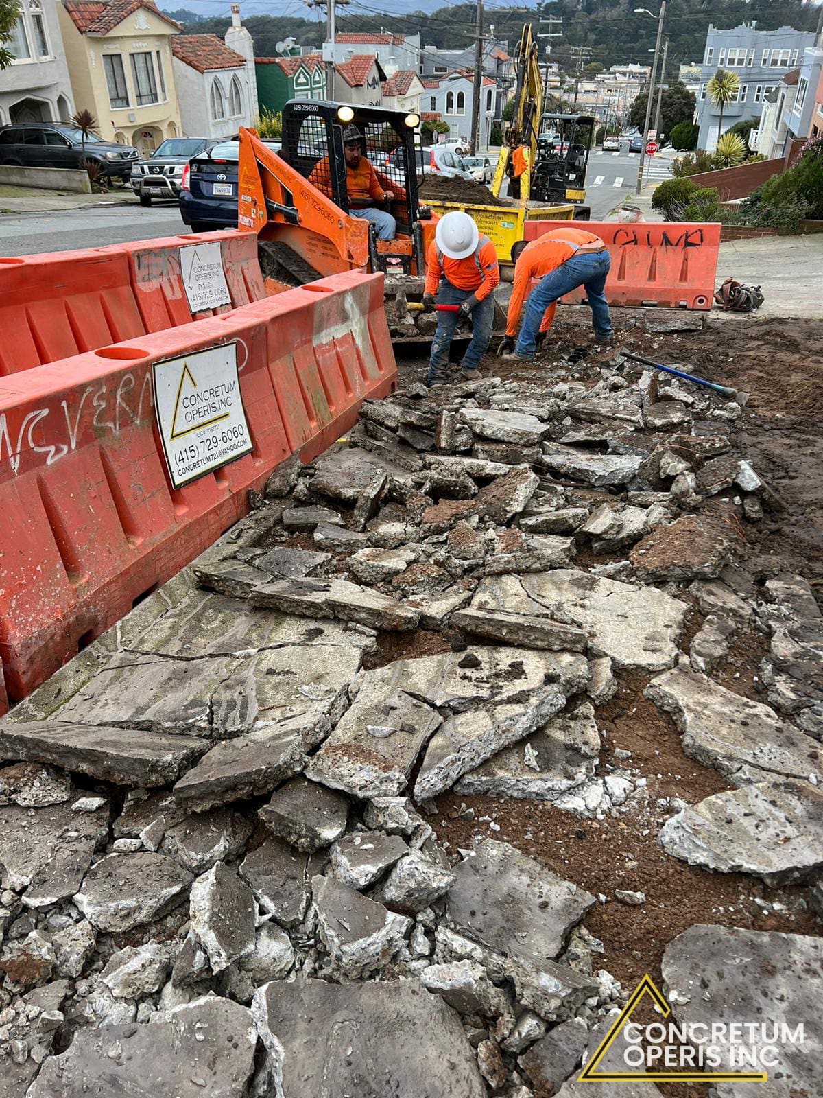 Crew clearing broken concrete debris from a San Francisco sidewalk demolition site