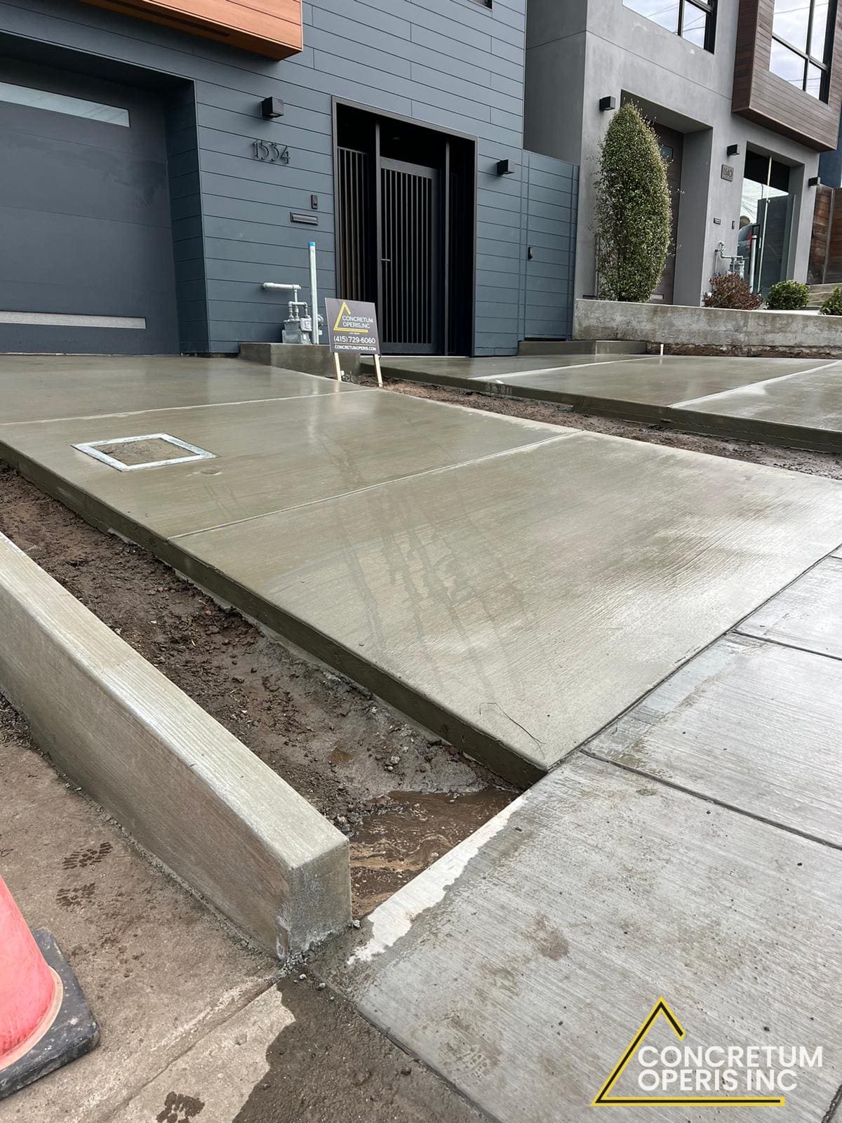 Worker finishing the surface of a freshly poured concrete driveway in San Francisco, CA