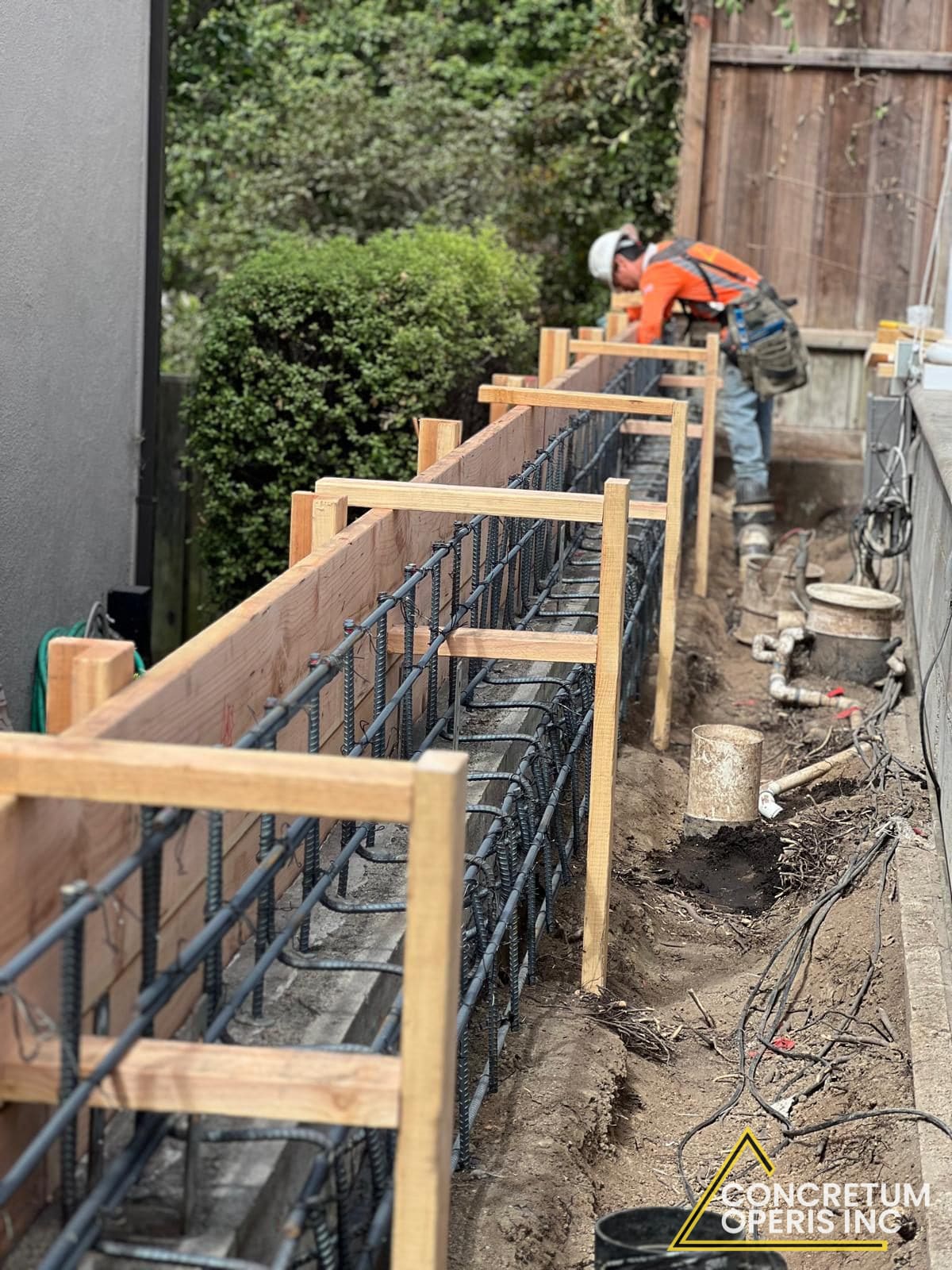 Rebar cage and wood formwork built for a concrete wall along a Richmond, CA backyard