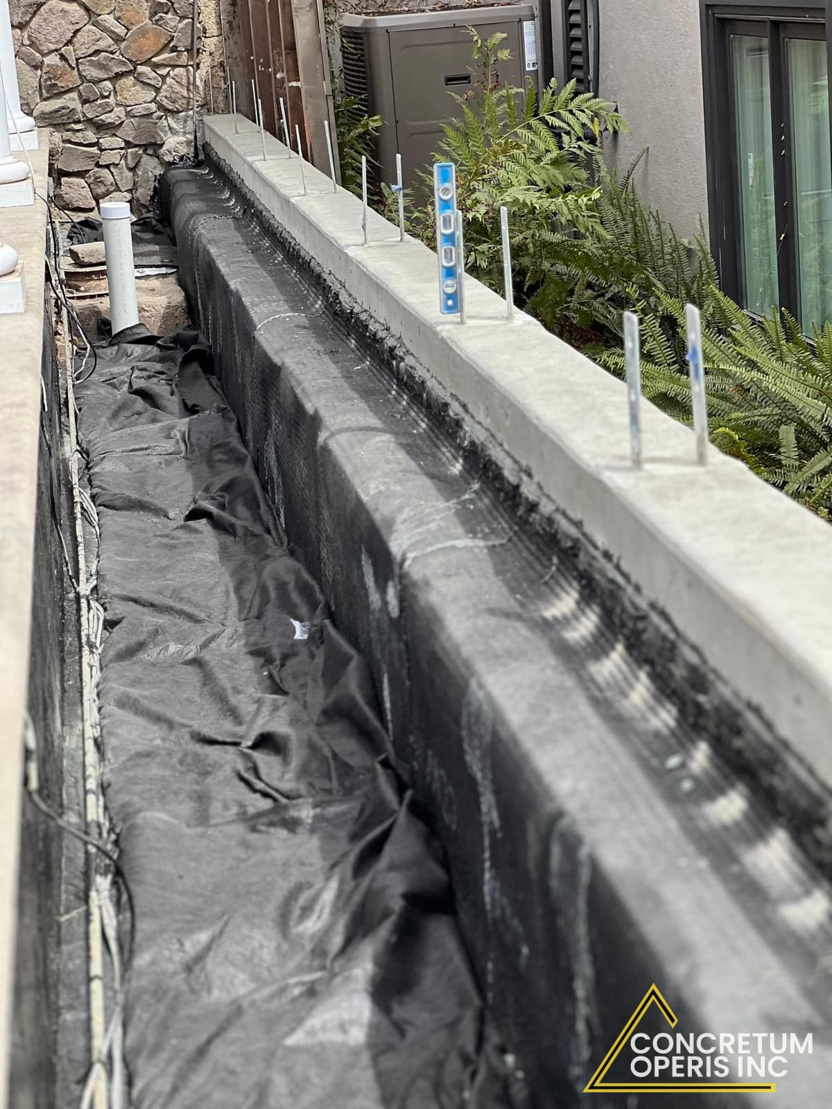 Waterproofing membrane and rebar dowels on a formed concrete retaining wall in Richmond, CA