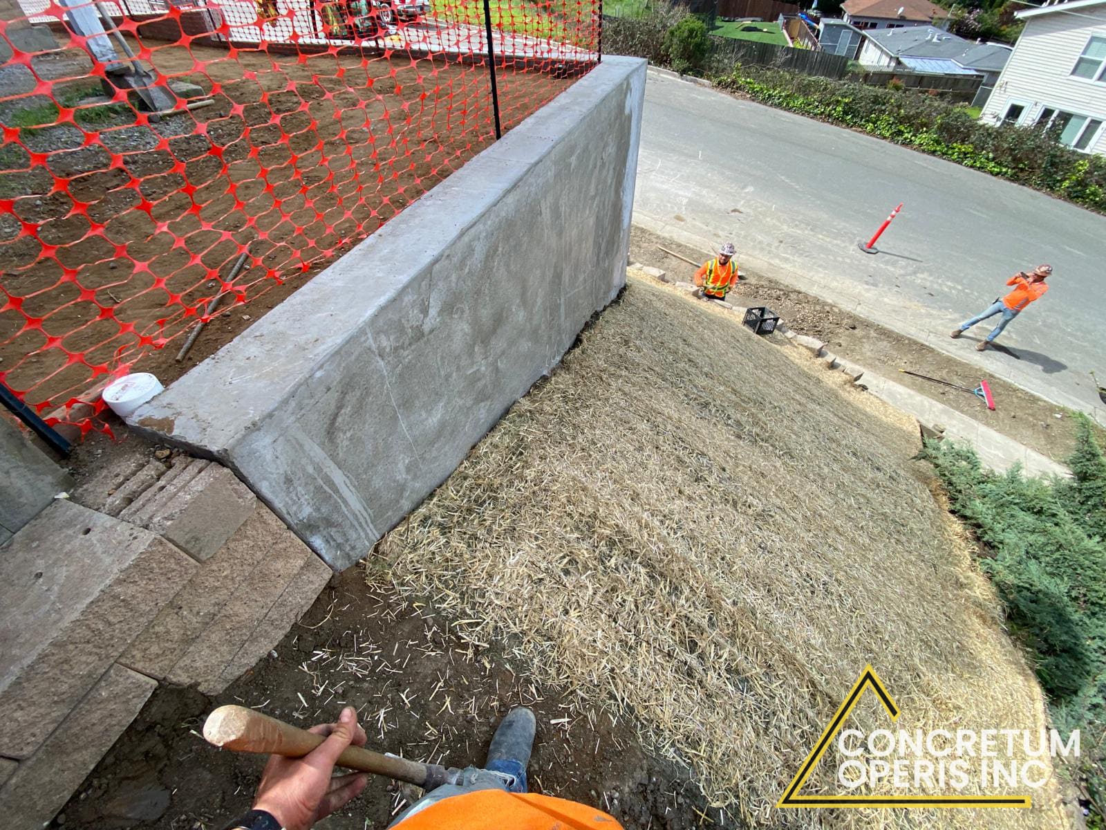 Aerial view of a poured concrete retaining wall with fresh hydroseed above it in Bonita, CA