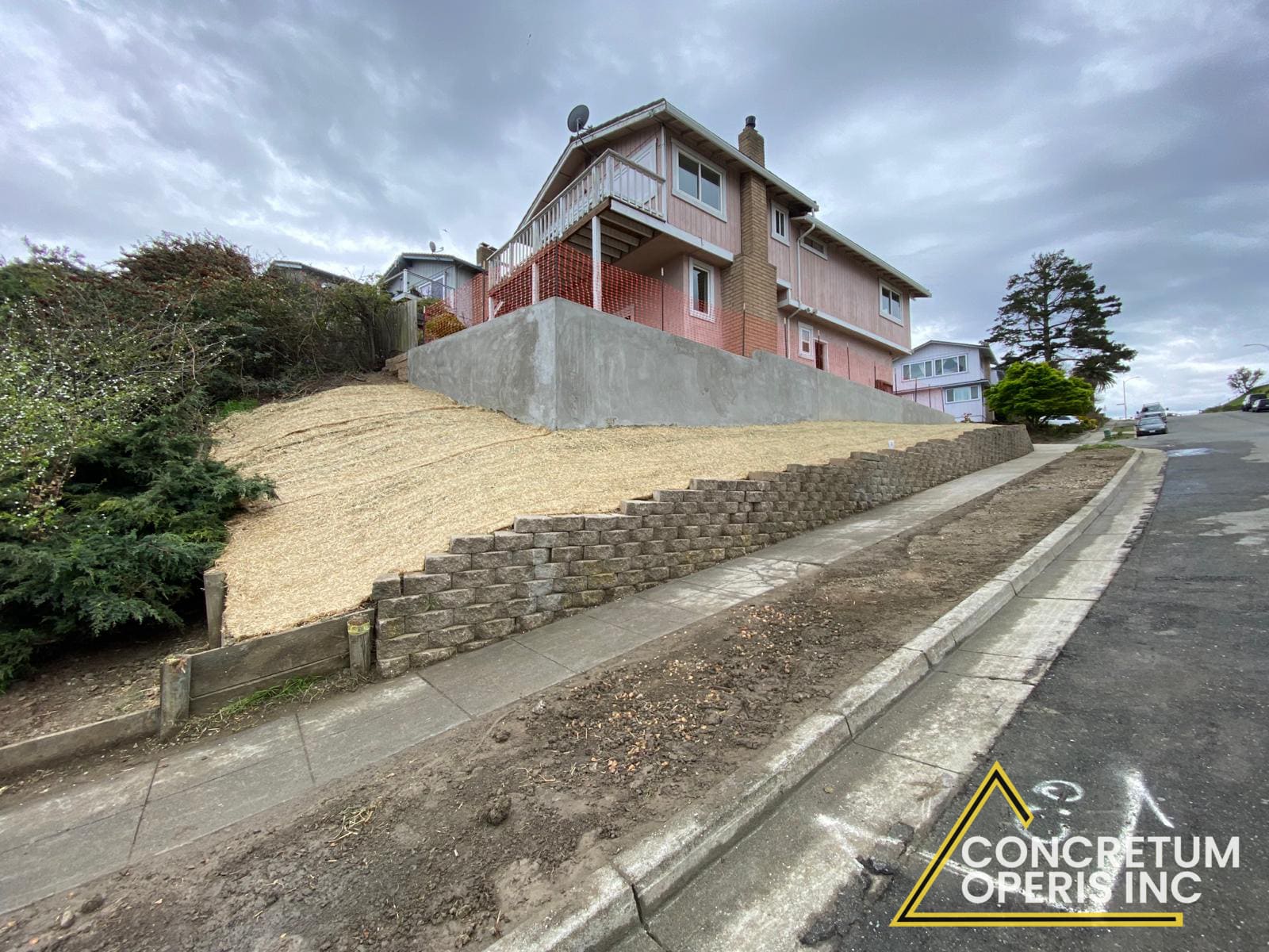 Freshly poured concrete retaining wall on a hillside property in Bonita, CA