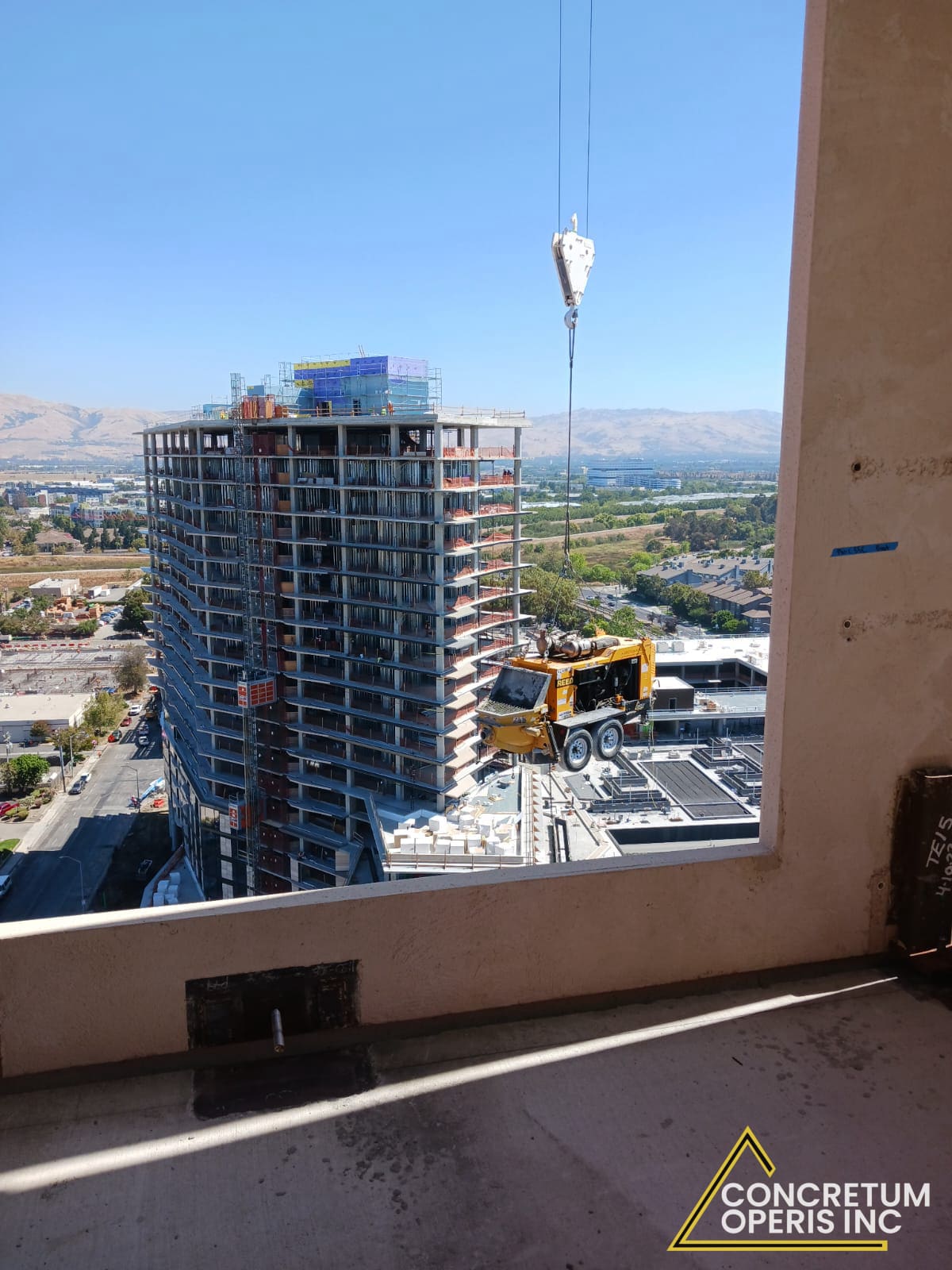Concrete mixer trailer craned onto a high-rise tower under construction in Santa Clara, CA