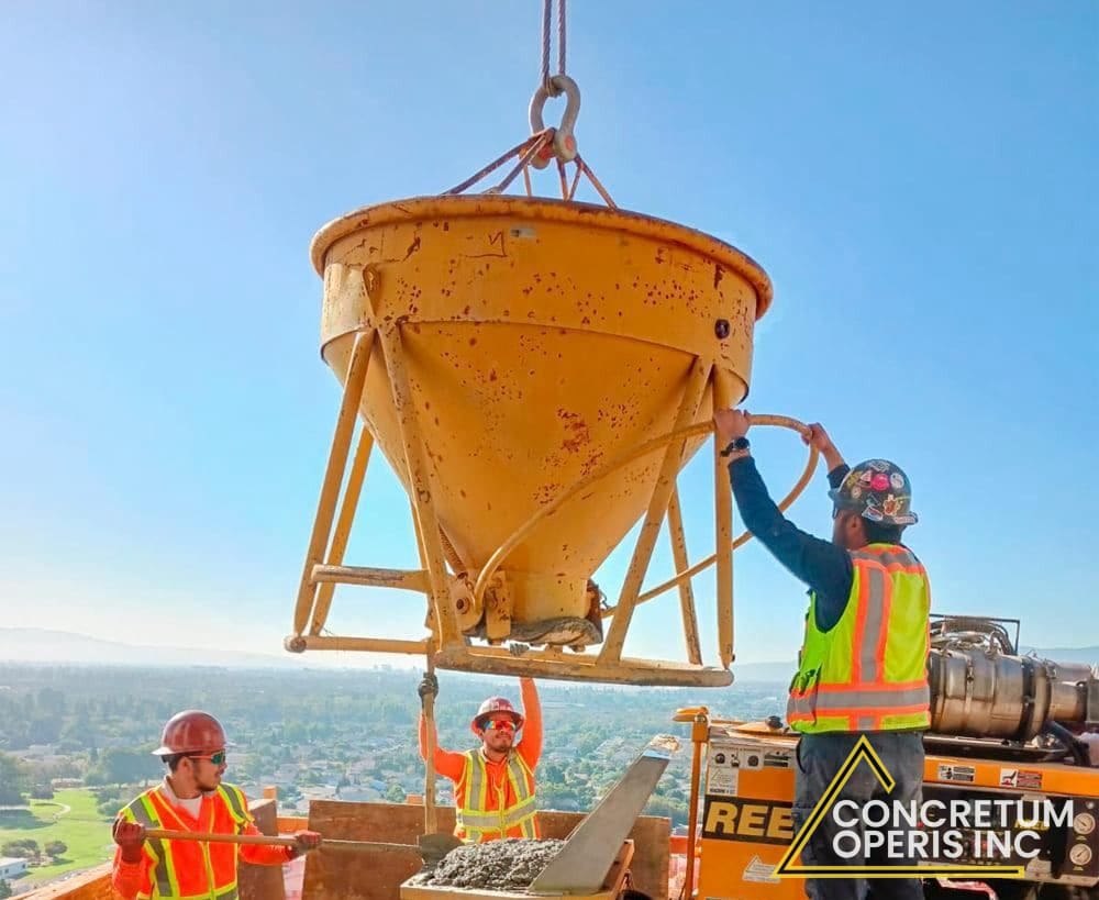 Ready-mix truck feeding a concrete pump bucket lifted by tower crane in Richmond, CA