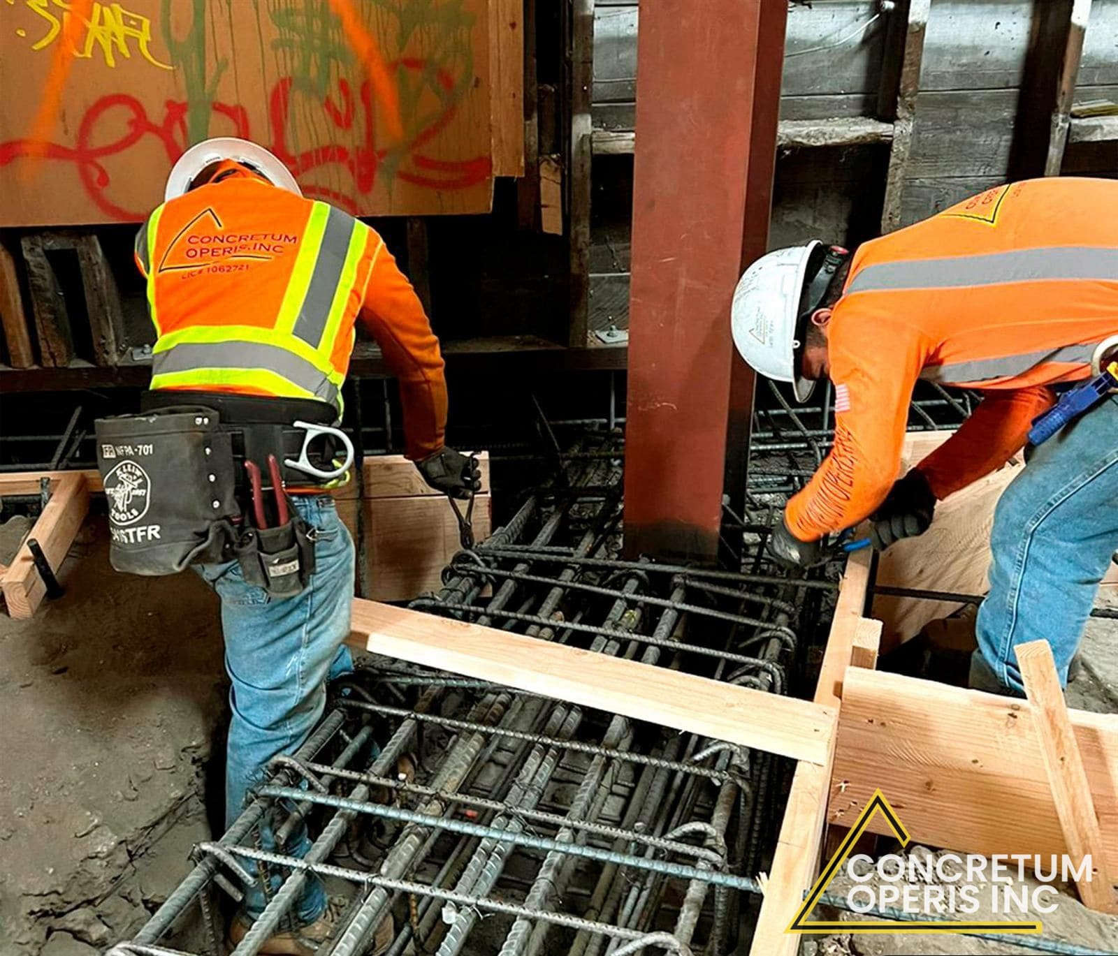 Crew tying rebar cages around a steel column inside a building in Richmond, CA