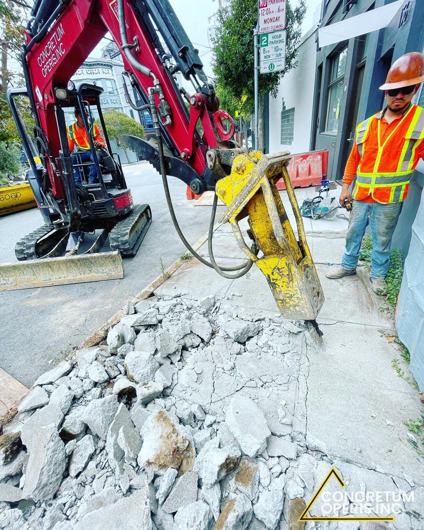 Mini excavator with hydraulic breaker cutting a concrete sidewalk in Richmond, CA