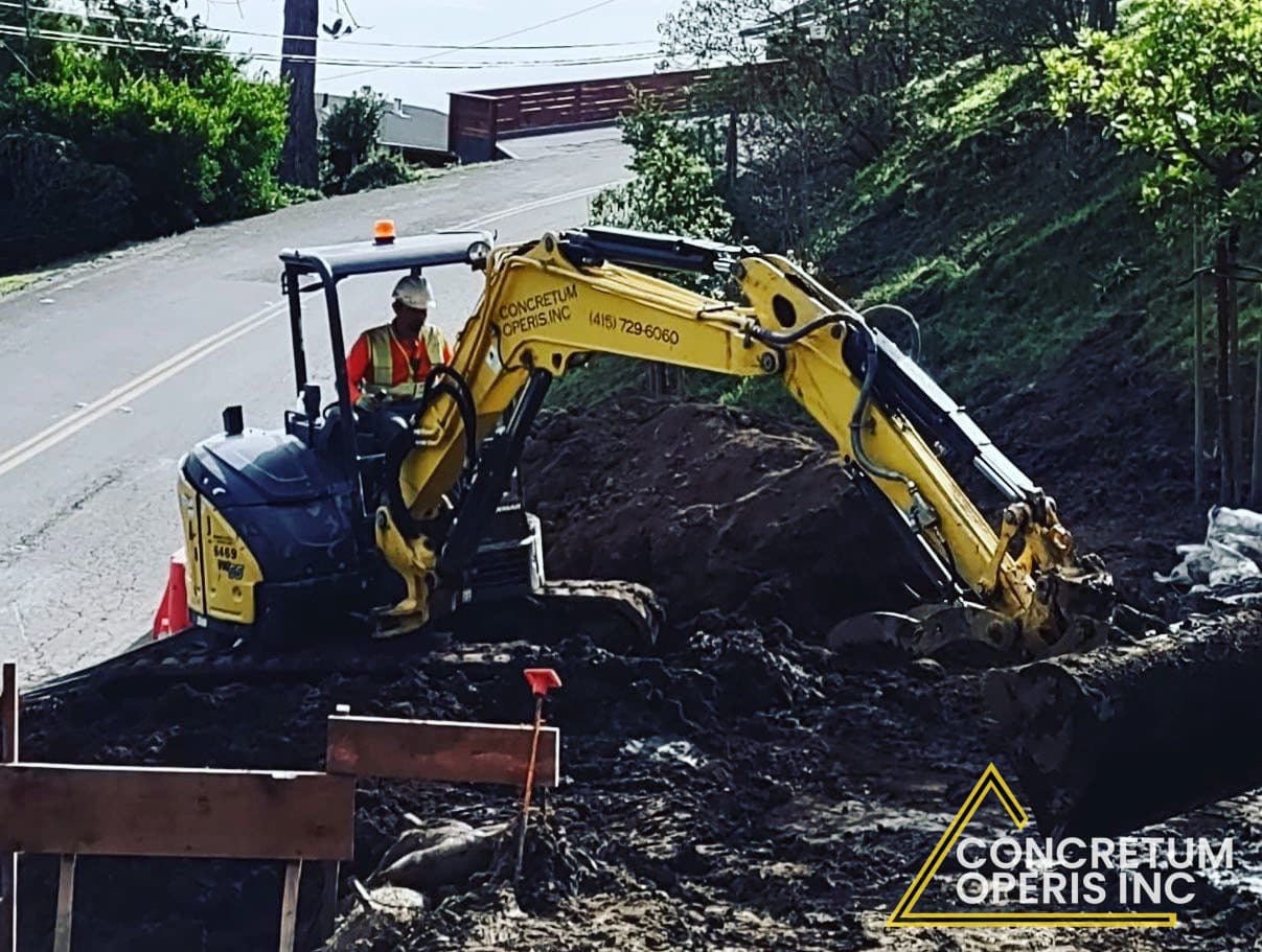 Mini excavator grading a hillside road shoulder in Richmond, CA