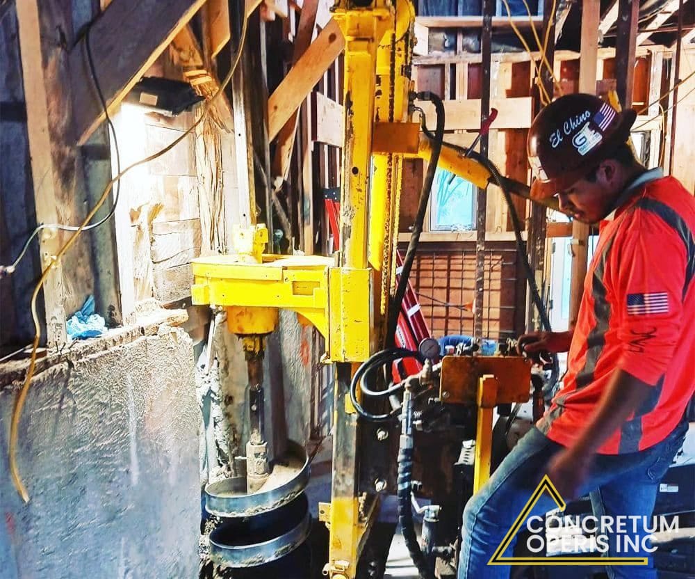 Crew operating a portable auger rig inside a home's crawl space in Richmond, CA