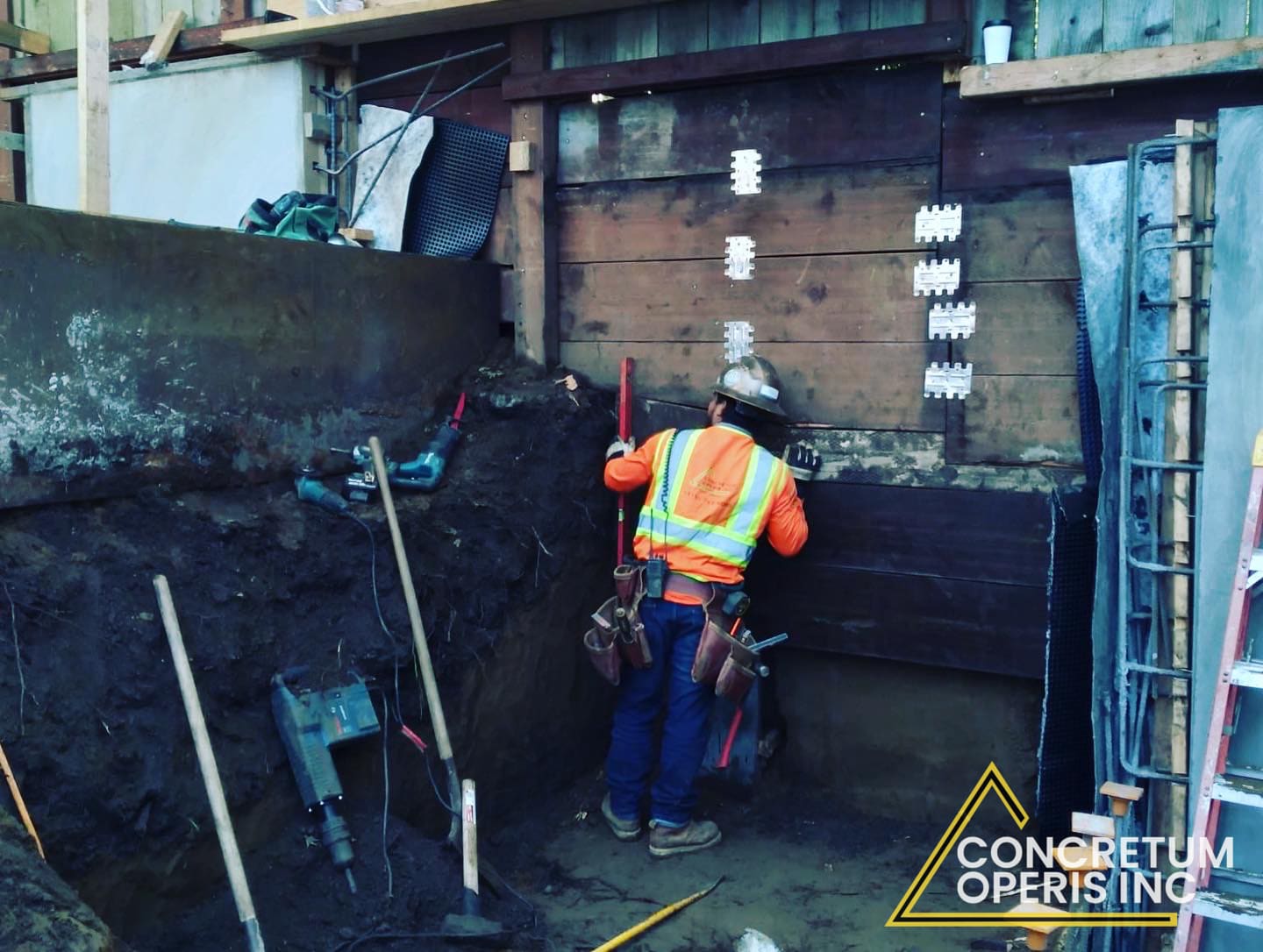 Worker installing seismic retrofit brackets along a foundation cripple wall in Richmond, CA