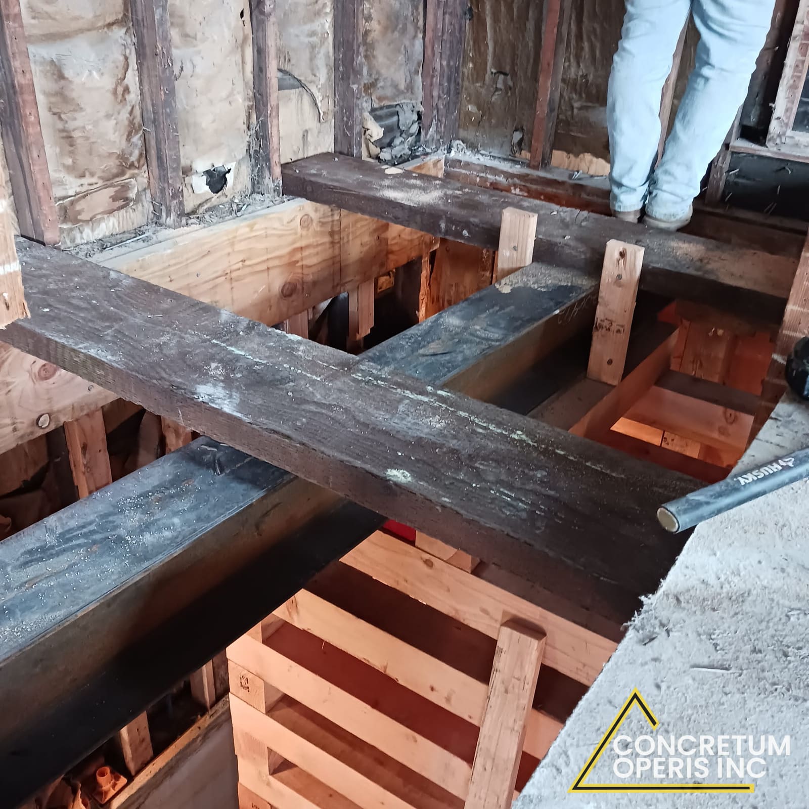 Steel beam and timber shoring supporting floor framing above a foundation excavation in Richmond, CA