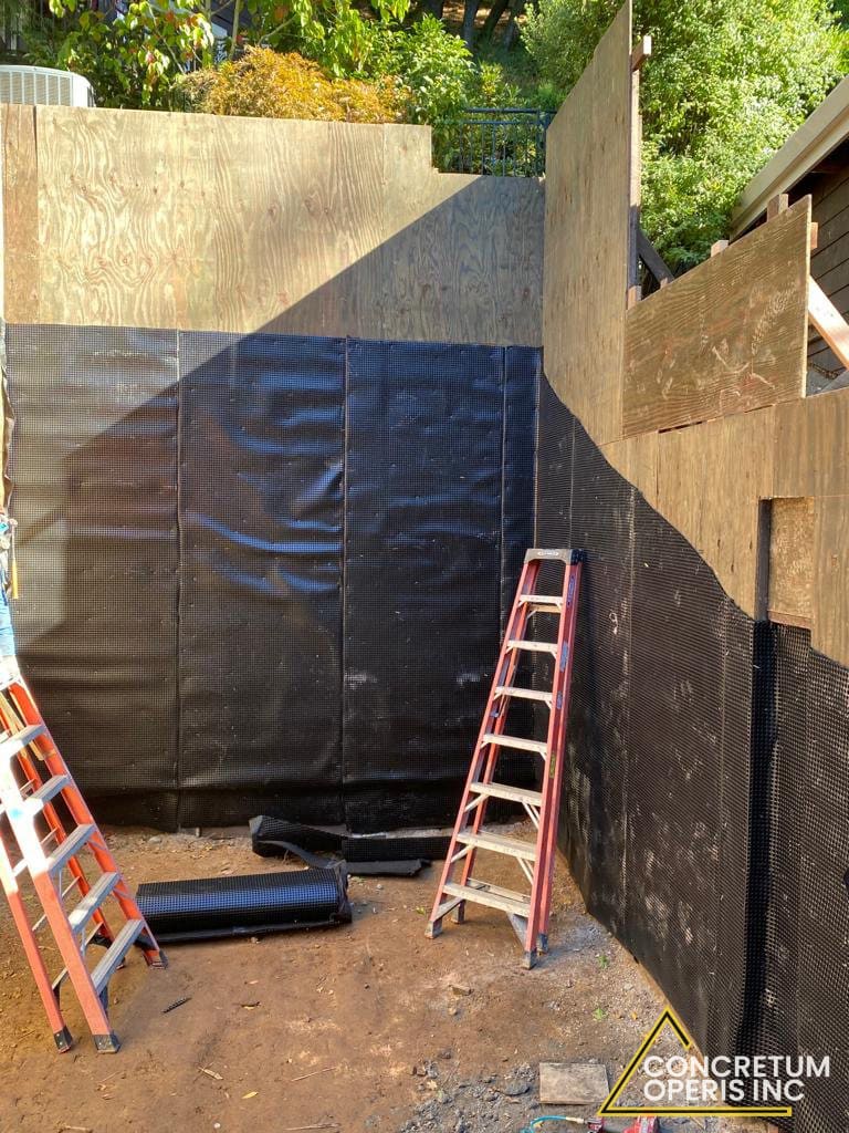Drainage membrane sheeting installed over a plywood foundation wall in Richmond, CA
