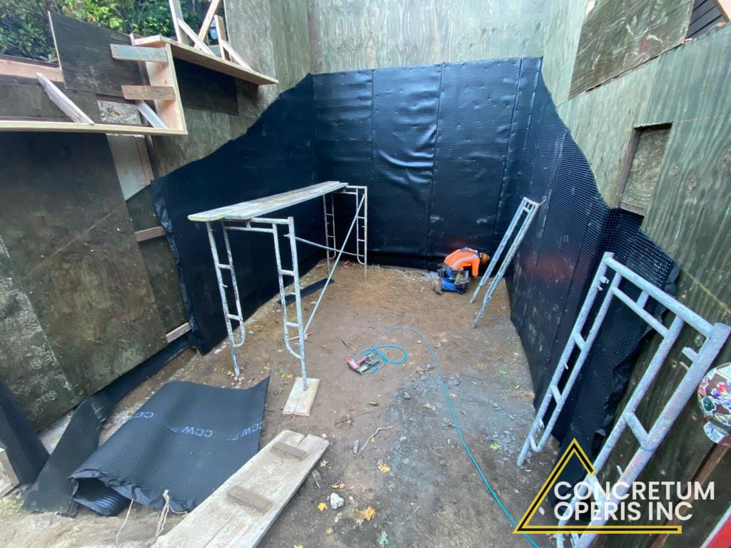 Waterproofing membrane installation in a below-grade foundation enclosure in Richmond, CA